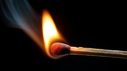 Close-up of igniting matchstick with bright flame on black background