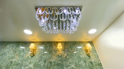 Elegant Wall Sconce Lamp with White Lampshade and Crystal Drop on Luxury Green Marble Wall in...