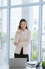 Fototapeta premium Confident Asian Businesswoman on Mobile Phone