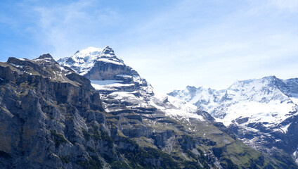 Fototapeta premium Majestic snow-capped mountains rise above lush green valleys, showcasing breathtaking natural beauty and inviting adventure in the serene alpine landscape of the Swiss Alps
