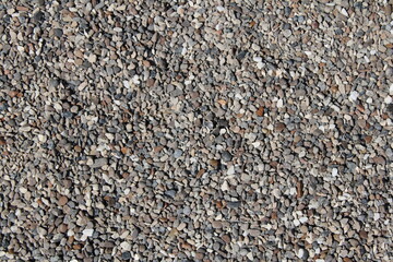Close-up view of a textured pile of pea gravel, perfect for landscaping, construction, and design...