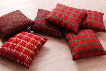 Set of red tartan pillows, creating a cozy rustic feel. Great for seasonal or home decor.
