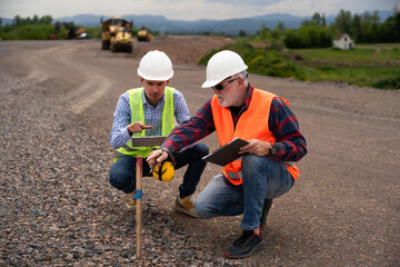 Engineers are discussing and working on a section of highway.