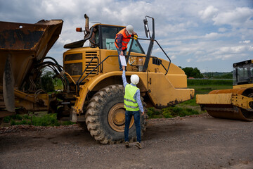 Engineers are discussing and working on a section of highway.
