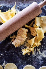 Raw yellow pasta with wooden pin roller