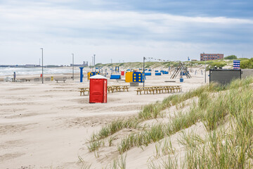 Wide sandy Ventspils Beach with colorful changing cabins and grassy Baltic dunes