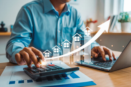 Businessperson analyzes real estate investment growth using a calculator and a laptop. An upward trending graph with house icons symbolizes rising property values and successful investment.