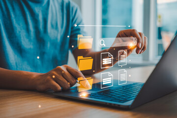 A person interacts with a laptop, displaying floating file icons and search graphics. The digital interface signifies modern data management and efficient file organization in a work setting.