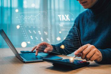 A person uses a laptop and calculator with a digital tax and financial data overlay, symbolizing modern technology in tax calculations and financial management, in a professional office setting.