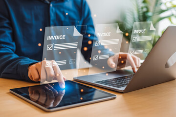 A person uses a tablet and laptop to manage digital invoices, emphasizing efficiency in business transactions. The technology streamlines invoice management, ensuring prompt and organized processing.