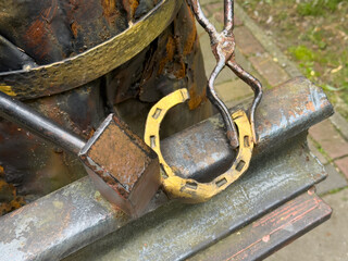Hands are skillfully shaping a horseshoe in a workshop. Tools lie nearby, reflecting the...