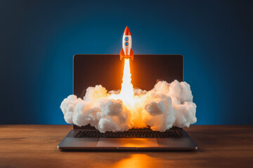 A rocket launches from a laptop screen, symbolizing technology and innovation. Fluffy clouds surround the device, highlighting creativity and new beginnings at the intersection of digital. 