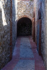 Narrow cobblestone passage with brick arch in Ceuta