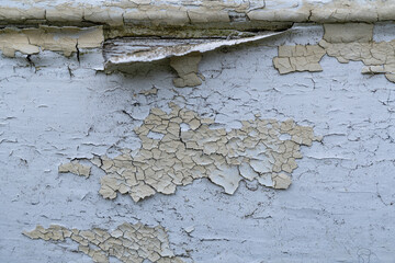 Peeling paint on weathered surface with cracks and texture
