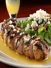 a plate of grilled sliced meat rests on a white surface, accompanied by a vibrant green salad. the meat is drizzled with a light sauce and sprinkled with crumbles of white cheese