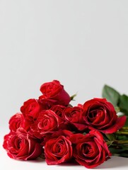 Obraz premium A bouquet of red roses on a table with a white background and copy space for an image