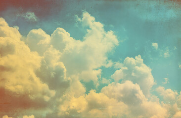 Vintage sky with fluffy white clouds, blue sky, and a faded yellow border for an old-fashioned feel. Vintage-style sky with white clouds, blue sky
