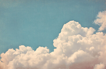 Vintage sky with fluffy white clouds, blue sky, and a faded yellow border for an old-fashioned feel. Vintage-style sky with white clouds, blue sky