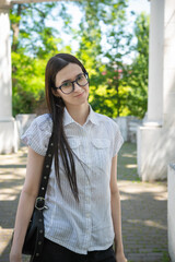 Young beautiful girl with glasses and long hair in the park