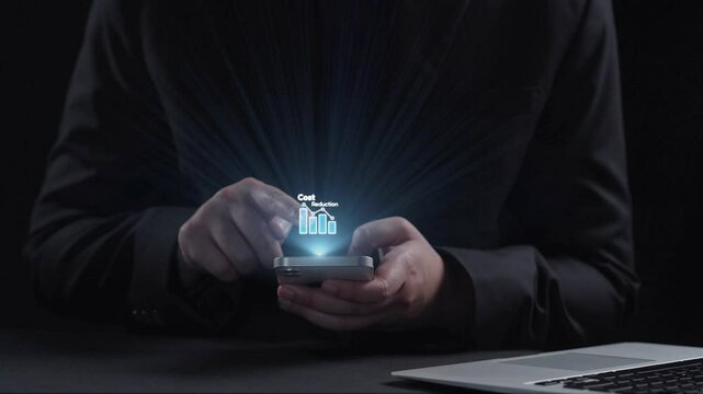 A person holding a smartphone displays virtual icons representing cost reduction and business analytics on a dark background, symbolizing financial strategies for growth. Qubit