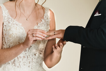 The bride puts a ring on the groom's finger