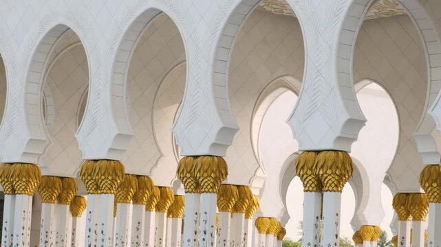 Details of interior of Sheikh Zayed Grand Mosque with ornate columns with golden paln tree decorations and arches in Abu Dhabi, UAE. Islamic art and architecture. Popular Arabic landmark