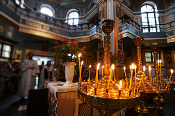 Interior of a traditionally styled church featuring glowing candles, intricate decor, and...