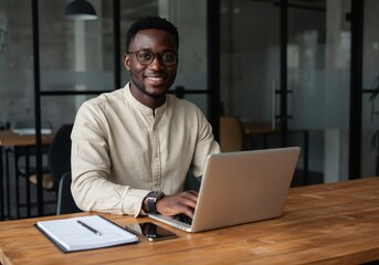 Handsome african american man working on laptop in modern office space for business and technology concept
