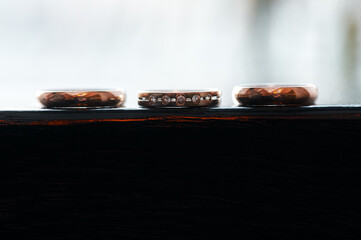Three Elegant Gold Rings Displayed on a Wooden Surface