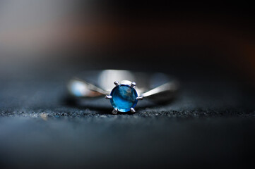 Elegant close-up showcasing a sapphire gemstone ring seated elegantly in a dim lighting setting.