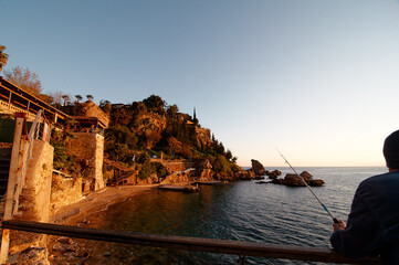 Coastal View at Sunset with Fishing by the Rocky Shores