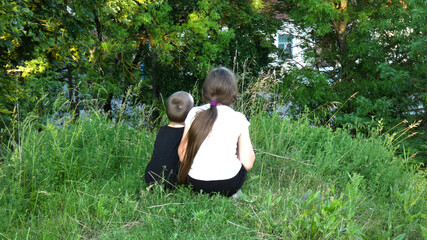 A girl and a boy are sguatting