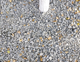 background of gravel and dry autumn leaves. gravel is laid out on the lawn in the park. dry leaves...