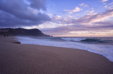 Scenic Beach at Sunset With Dramatic Clouds and Rolling Waves