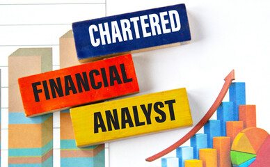 CHARTERED FINANCIAL ANALYST- words on multi-colored wooden blocks on the background of charts