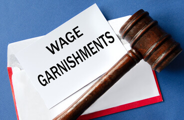 WAGE GARNISHMENTS - words on a white sheet of paper against the background of an envelope and a...