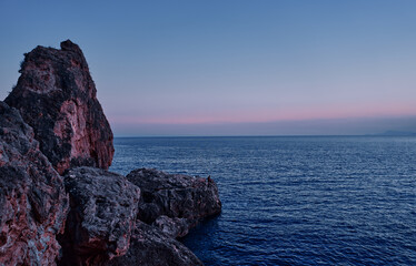 Dramatic Coastal Rock Formation and Serene Ocean at Sunset