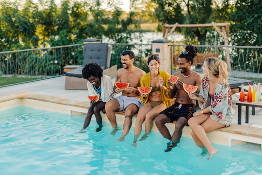 Friends eating watermelon by the poolside during summer vacation - Powered by Adobe
