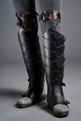 High-angle view of black leather boots with intricate patterns and metallic studded detailing,...