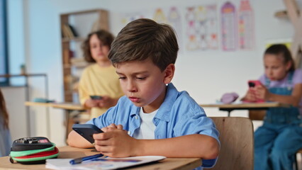 Children using gadgets classroom at group activity. Students elementary school