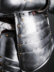 Close-up of polished steel plate armor with brass rivets and articulated segments, showcasing...