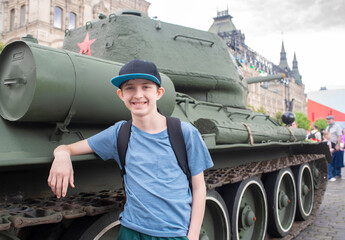 A 12-year-old boy stands next to a Soviet T-34 tank at the 