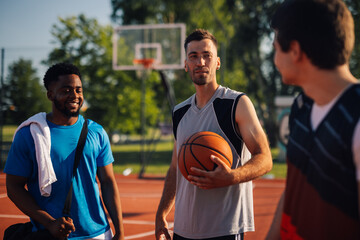 Basketball player holding ball and talking to teammates on court