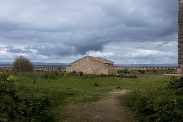 Medieval stone building inside loarre castle walls under cloudy sky