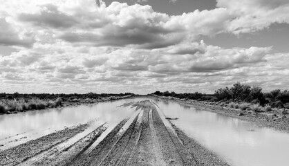 Imagem em preto e branco mostrando um trecho de estrada de rípio na Patagônia Argentina com...