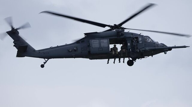 Close Up Tracking Shot of Military Helicopter in Flight Against Cloudy SKy