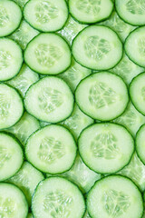 Fresh green slices of cucumber as background.