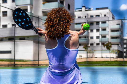 Woman pickleball player preparing to serve on court