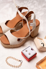 Bridal accessories with beige platform sandals, pearl jewelry and wedding rings
