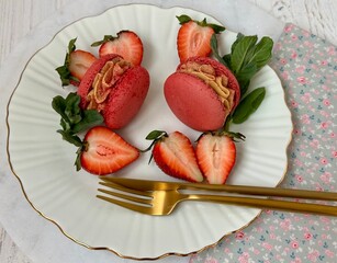French dessert macarons and strawberries on the white plate